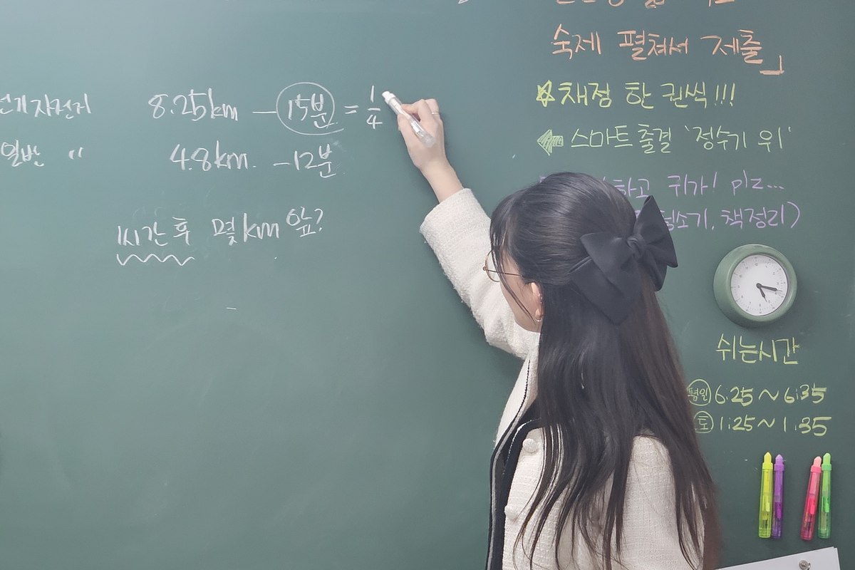 백마 초등수학학원 민주쌤이 칠판에서 초등 수학을 소수정예로 지도하는 모습